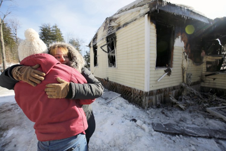 Cherie Eastman, right, hugs Kira Harmon while surveying Eastman's fire-damaged home on Tuesday morning. Eastman maintained her sense of humor during the tour, joking that the fire destroyed the home she designed and built with her husband and late father, but somehow spared a stack of cordwood, the back deck, and a nearby shed that she considers an eyesore.