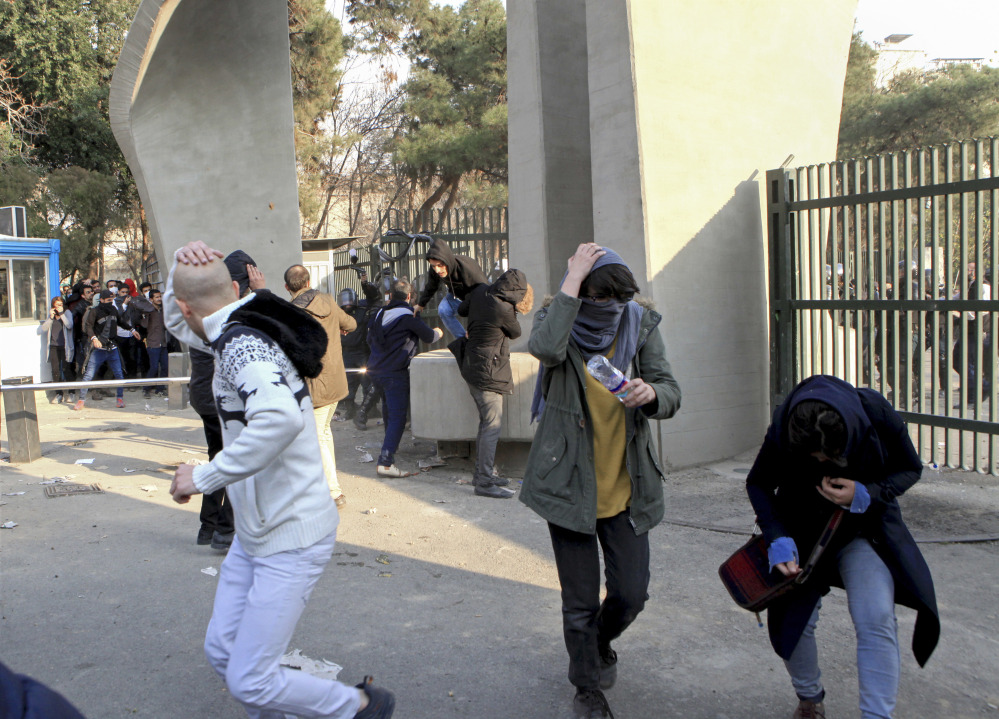 University students run away from stones thrown by police during an anti-government protest inside Tehran University, in Tehran, Iran. The photo was taken on Dec. 30, 2017, by an individual not employed by the Associated Press and obtained by the AP outside Iran.