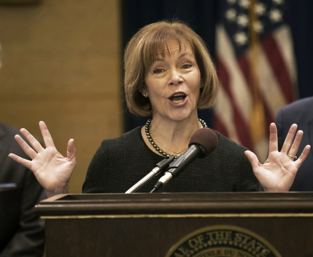 FILE - In this Wednesday, Dec. 13, 2017, file photo, Minnesota Lt. Gov. Tina Smith speaks as Gov. Mark Dayton listens during a news conference in St. Paul, Minn., as Smith was named to replace fellow Democrat Al Franken in the U.S. Senate. Franken announced his resignation a week earlier amid growing sexual misconduct allegations. Smith is vowing to "hit the ground running" as she joins the U.S. Senate the first week of 2018 while preparing to run in November. (Brian Peterson/Star Tribune via AP, File)