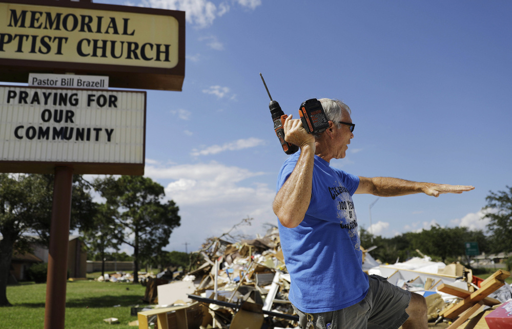 Wayne Christopher sifts through debris outside his damaged church from Hurricane Harvey in Port Arthur, Texas, last fall.