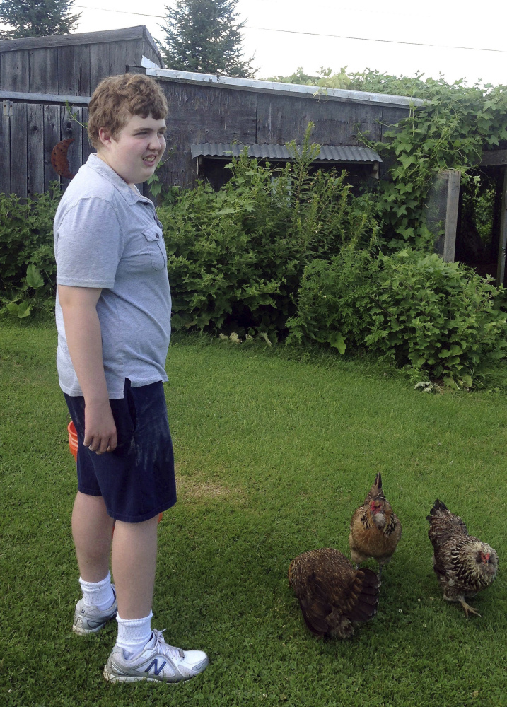 Ben Pollack tends to chickens in a yard in Sidney in 2013. His parents say they want Ben, who is autistic and nonverbal, to be able to wear an always-on recording device at school so they can get a glimpse into his day to help them ensure he's being treated properly and getting the most out of his education.
