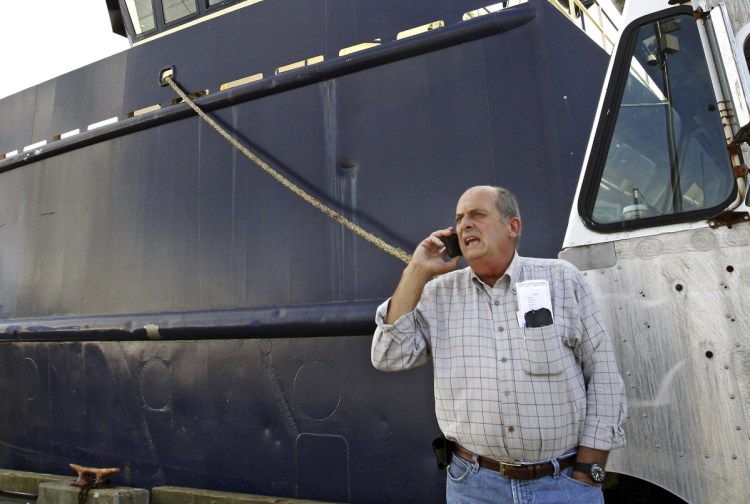 FILE - In this 2014 photo, Carlos Rafael talks on the phone at Homer's Wharf near his herring boat F/V Voyager in New Bedford, Mass. 