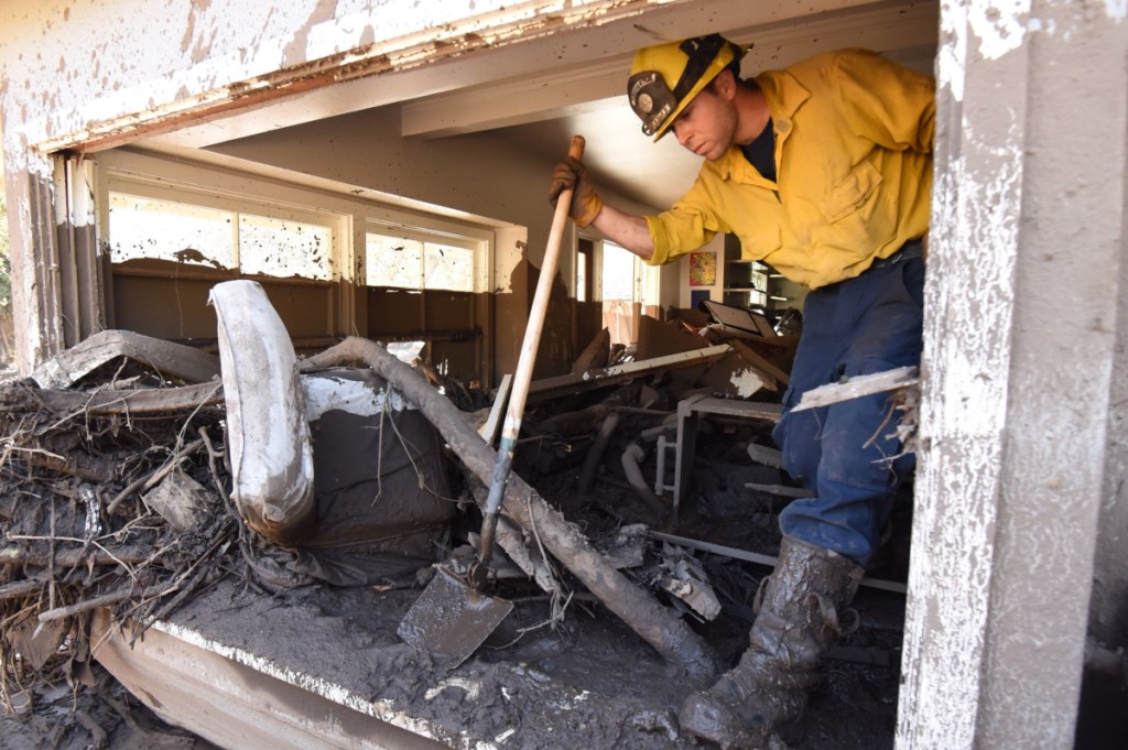 Santa Barbara County firefighter Vince Agapito climbs through a Montecito, Calif., home Saturday that was destroyed by deadly mudflow and debris early Tuesday morning following heavy rainfall. (Mike Eliason/Santa Barbara County Fire Department via AP)