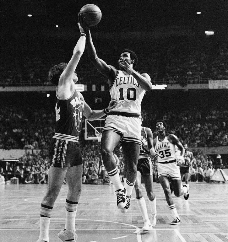 Jo Jo White of the Boston Celtics lays up a shot over Golden State's Rick Barry on Feb. 29, 1976. The Celtics went on to win the NBA Finals that season. White, who played a key role for the Celtics in that series, died on Tuesday at age 71 after a battle with cancer.