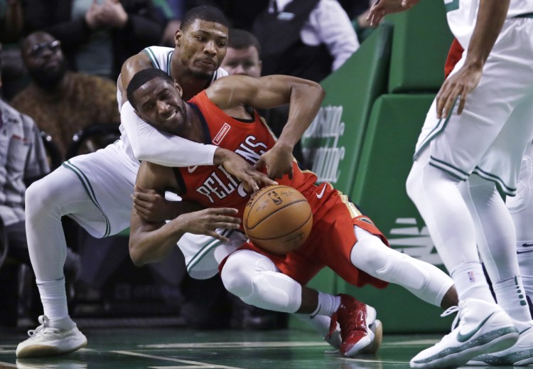 Boston's Marcus Smart, rear, reaches around and knocks the ball from the hands of New Orleans Pelicans guard Ian Clark in the second half Tuesday night in Boston.