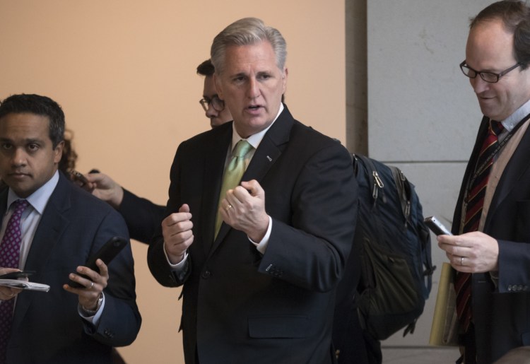 Majority Leader Kevin McCarthy, R-Calif., walks with reporters as work continues on preventing a weekend federal shutdown, at the Capitol in Washington on Wednesday. If Congress can't temporarily finance the government by Friday, a shutdown would begin the next day.