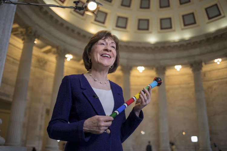 Sen. Susan Collins, R-Maine, who moderated bipartisan negotiations in her office to break the government shutdown stalemate, describes the power of the centrists and her efforts to keep the talks civil, during a TV news interview on Capitol Hill in Washington on Tuesday. Collins holds a ceremonial "talking stick," a gift from Sen. Heidi Heitkamp, D-N.D., which was passed from senator to senator. Only the senator in possession of the "talking stick" could speak as others were listened.
