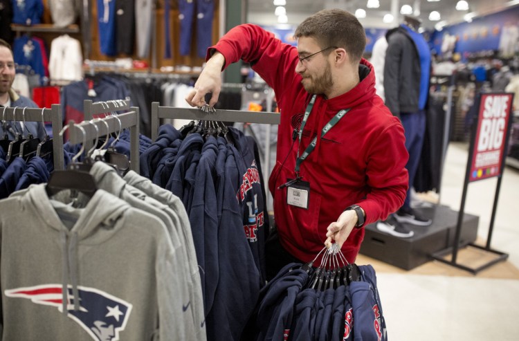 Kyle Jandreau puts out new Patriots merchandise at South Portland Dick's Sporting Goods. The store opened at 6 a.m. Monday.