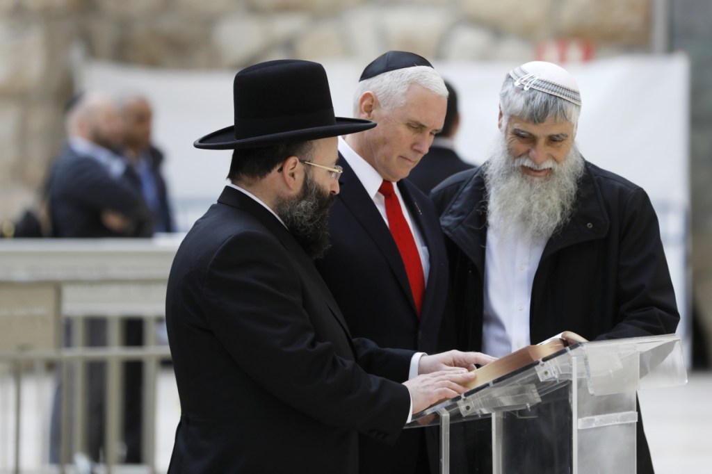 Vice President Mike Pence examines a book with Western Wall Heritage Foundation Director General Mordechai Elias, right, and Rabbi of the Western Wall Shmuel Rabinovitch during a visit to the Western Wall, Judaism's holiest prayer site, on Tuesday.