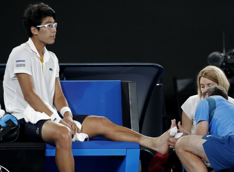 South Korea's Hyeon Chung receives treatment from a trainer during his semifinal against Roger Federer at the Australian Open.