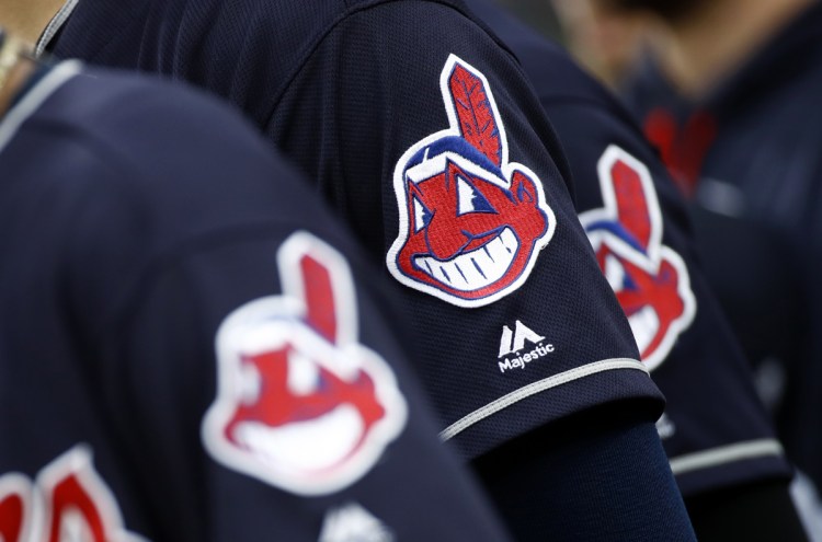 Members of the Cleveland Indians wear uniforms featuring mascot Chief Wahoo as they stand on the field for the national anthem before a game against the Orioles in Baltimore. Cleveland is taking the divisive Chief Wahoo logo off their jerseys and caps, starting in 2019.