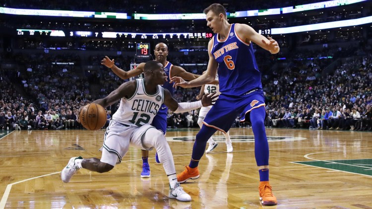 New York's Kristaps Porzingis tries to trap Boston's Terry Rozier on a drive to the basket during the first quarter Wednesday night in Boston.