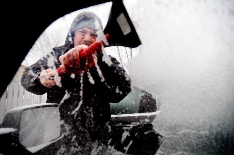 Joseph Albino, of South Portland, scrapes ice off his vehicle's windows before heading off to work Tuesday morning.