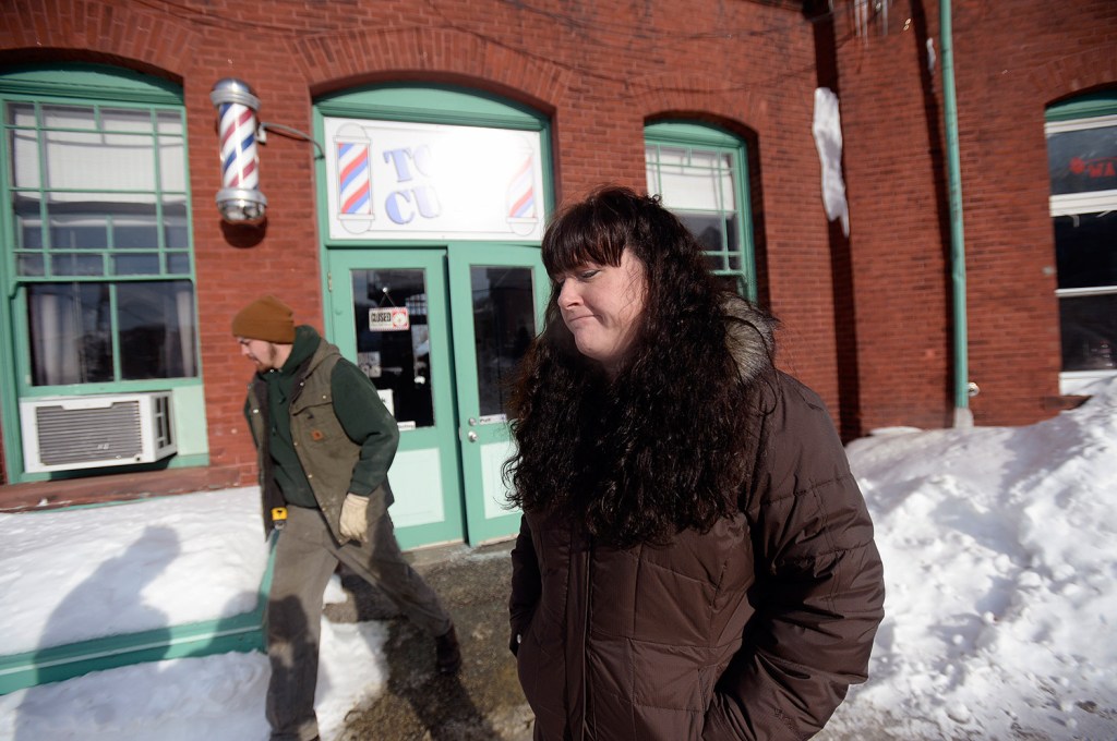 Ginny Ayers, owner of Top Cuts Barber Shop, stands outside the shop Tuesday after pipes in the building burst because of the frigid temperatures.