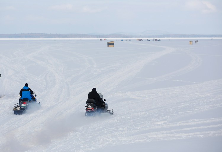 Ice fisherman haul their gear with snowmobiles Friday at Lower Bay on Sebago Lake. A Maine Warden Service spokesman said snowmobilers should avoid lakes and ponds unless they are certain of the ice conditions.
