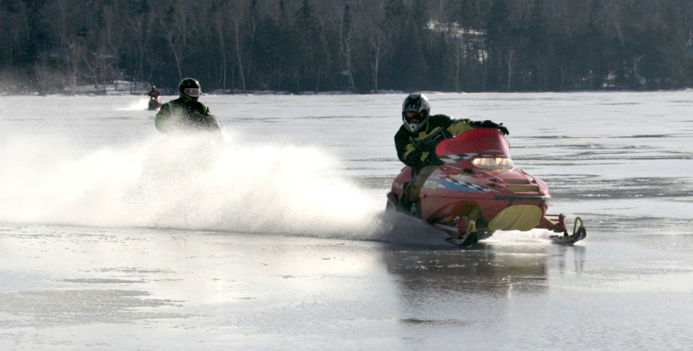Snowmobilers plow through six inches of water on top of frozen Rangeley Lake during the Snodeo in Rangeley last year.