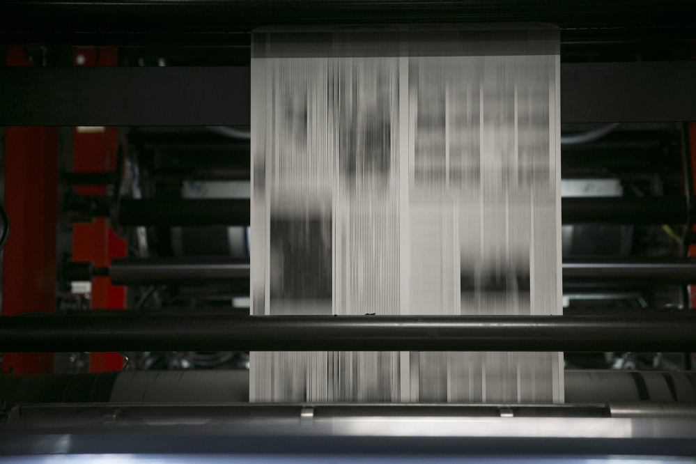 Newsprint runs through the printing cylinders of a newspaper press at The Washington Post production facility in Springfield, Virginia, on July 12, 2013. (Andrew Harrer/Bloomberg)