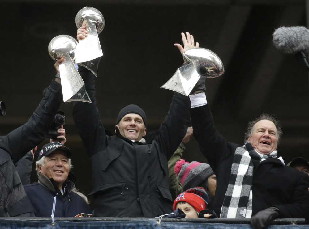 In this Feb. 7 file photo, Patriots quarterback Tom Brady holds up a Super Bowl trophy along with head coach Bill Belichick, right, and team owner Robert Kraft, left, during a rally in Boston to celebrate a 34-28 win over the Atlanta Falcons in Super Bowl 51. The Patriots say a report suggesting a rift involving Kraft, Belichick and Brady is "flat-out inaccurate."