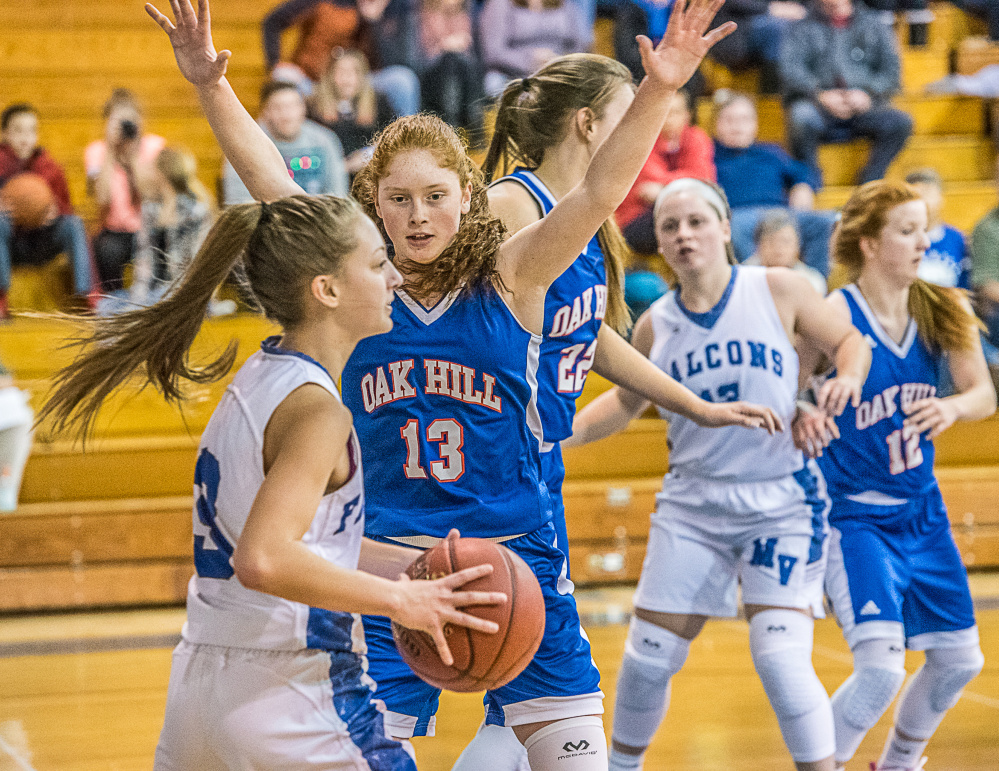 Mountain Valley's Brooke Carver, front, looks for a teammates Oak Hill's Desirae Dumais defends during Friday night's game in Rumford.