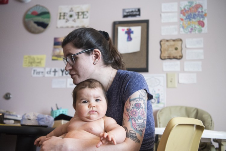 Kayla Clifton sits with her baby Lilly at the Mid-Maine Homeless Shelter on Wednesday. Karen Normandin, dean of students at Kennebec Valley Community College, is working with Clifton to pay off a back bill and get financial aid so she can return to her studies.