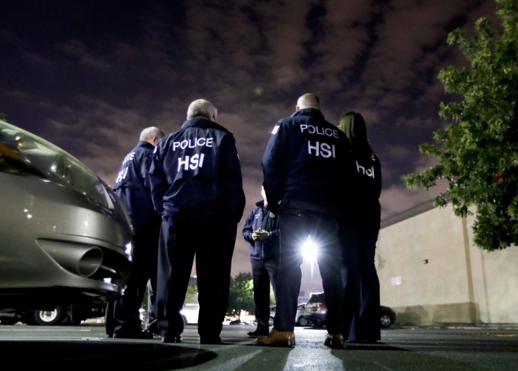 U.S. Immigration and Customs Enforcement agents gather Wednesday before serving a employment audit notice at a 7-Eleven convenience store in Los Angeles. Agents said they targeted about 100 7-Eleven stores nationwide Wednesday to open employment audits and interview workers.