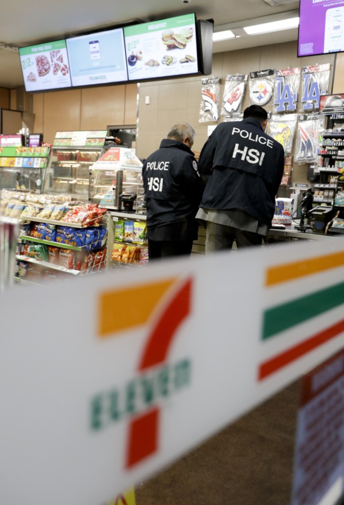 U.S. Immigration and Customs Enforcement agents serve an employment audit notice Wednesday at a 7-Eleven convenience store in Los Angeles. Agents said they targeted about 100 7-Eleven stores nationwide Wednesday to open employment audits and interview workers.