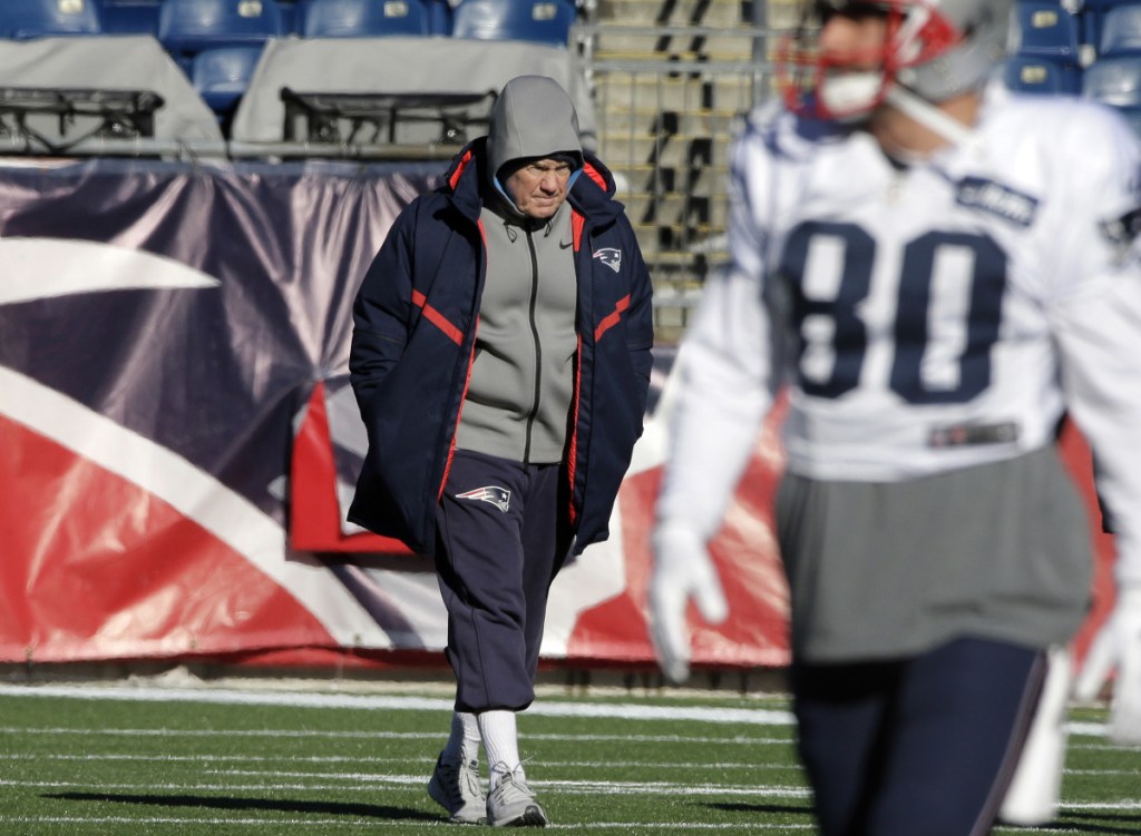 Patriots head coach Bill Belichick, center, walks on the field as wide receiver Danny Amendola warms up during practice Wednesday at Gillette Stadium.