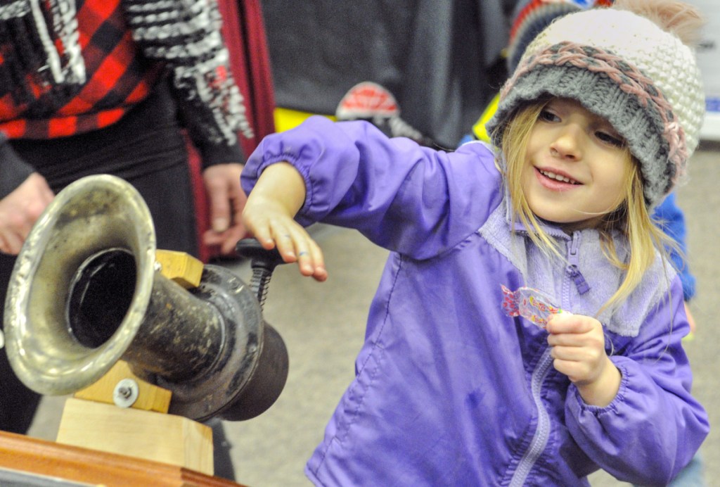 Molly Steward, 5, of Farmingdale presses a button to activate an antique Klaxon car horn in the Owls Head Transportation Museum during the Northeast Motorsports Expo at the Augusta Civic Center on Friday. The museum's display also featured an antique race car and motorcycle.