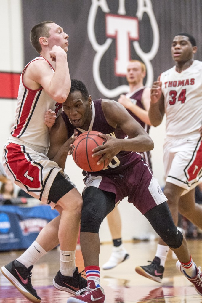 University of Maine at Farmington's Amir Moss, right, is called for an offensive foul as he plows through Thomas College's Zach Mackinnon on Saturday at Thomas College in Waterville.