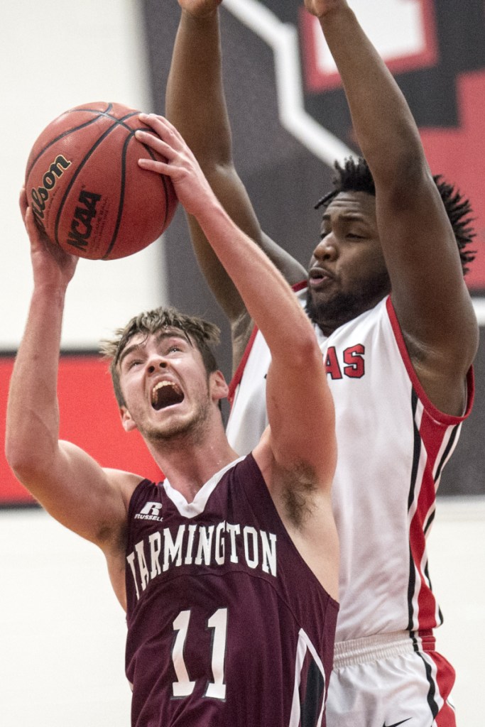 University of Maine at Farmington's Isaac Witham (11) draws the foul from Thomas College's Justin Butler (14) on Saturday at Thomas College in Waterville.