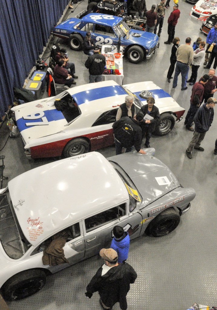 People look at cars on display at the Wicked Good Vintage Racing Association booth Saturday at the Augusta Civic Center.