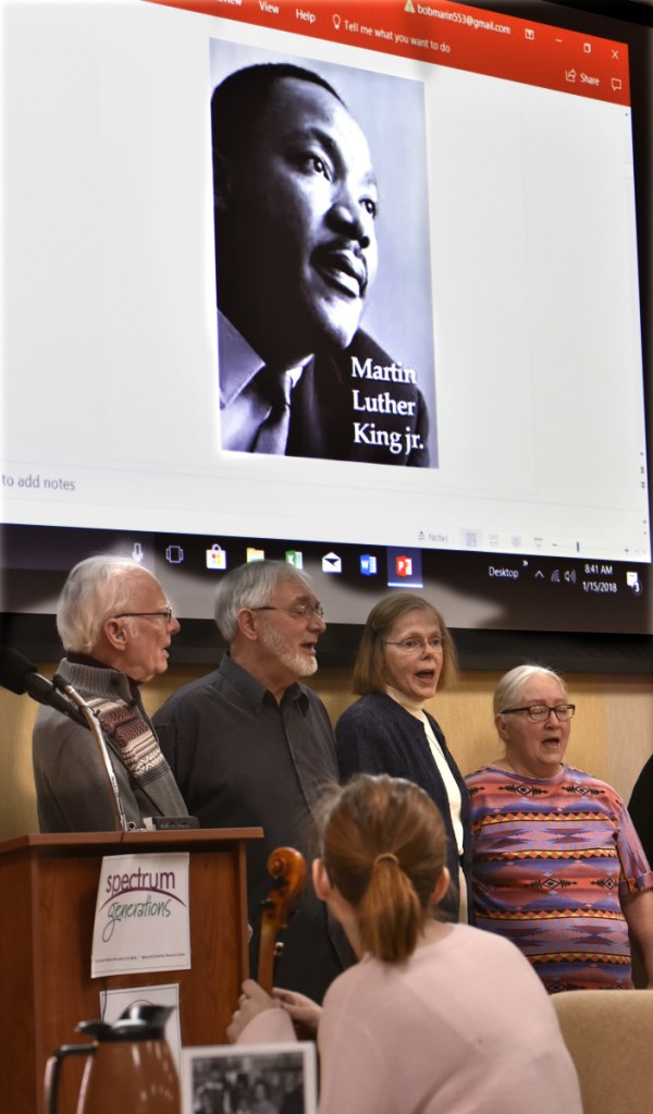 Members of the Tourmaline Singers sing under a projected image of Martin Luther King Jr. during the 32nd annual Martin Luther King Jr. Community Breakfast at the Muskie Center in Waterville on Monday.