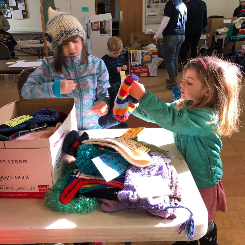 Eleanor Gagne, 7, left, and Emma Karnes, 5, both of Hallowell, help sort and tag donated winter hats at the Martin Luther King Jr. Day of Service on Monday at the Augusta Community Warming Center.