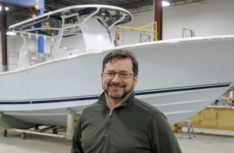 Southport Boats chief operating officer George Menezes with a 33-foot model of the vessel the firm manufactures at their new facility in Gardiner on Monday. Southport Boats, formerly part of Augusta's Kenway Corp., has relocated to Gardiner under new ownership and will continue to produce its line of center console fishing boats there.