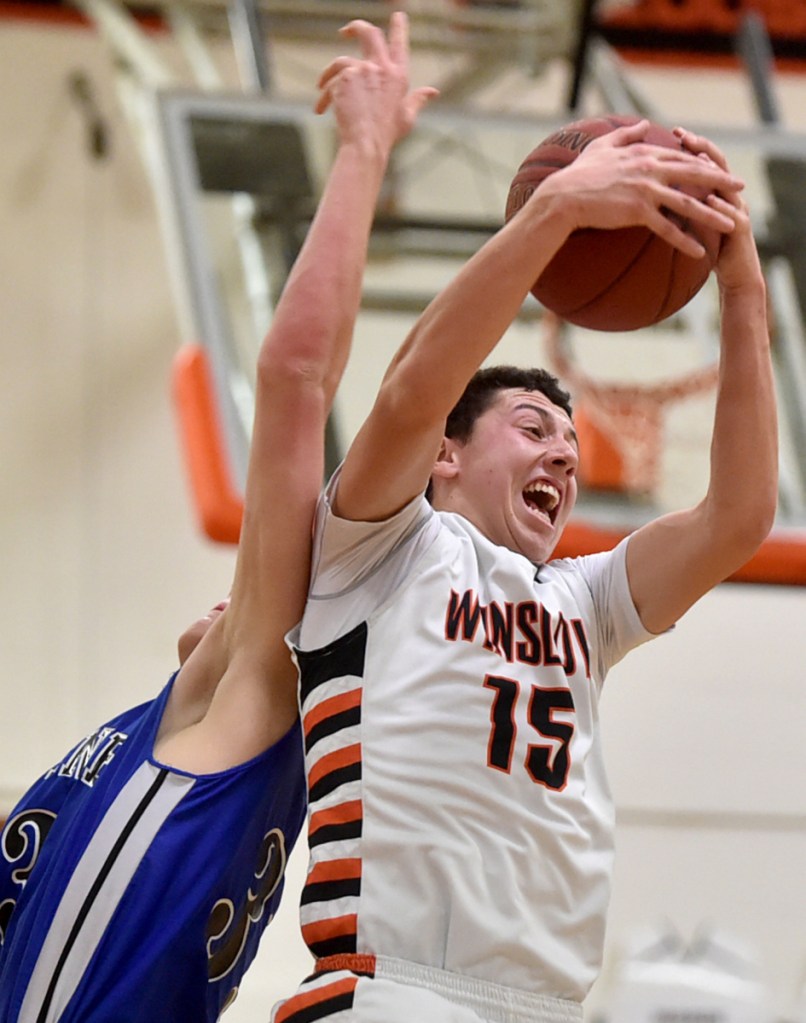Winslow's Jack Morneault (15) grabs a rebound in a game against Erskine last season. Morneault and the Black Raiders are 8-3 and in fourth place in Class B North.