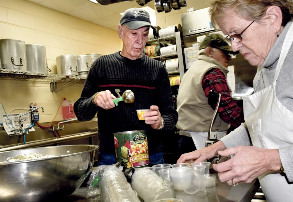 Roger Derosier, Dot Marshall and other volunteers prepare meals Monday for the Meals on Wheels program at the Muskie Center in Waterville.
