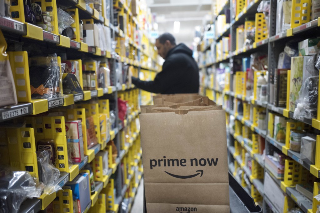 In this Wednesday, Dec. 20, 2017, file photo, A clerk reaches to a shelf to pick an item, Dec. 20, 2017 for a customer order at the Amazon Prime warehouse, in New York. Amazon announced Thursday that it has narrowed down its potential site for a second headquarters in North America to 20 metropolitan areas, mainly on the East Coast.