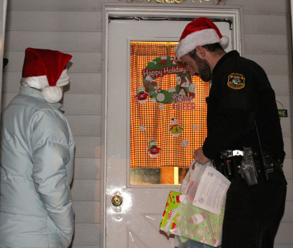 Dispatcher Jeanne Kempers, left, with Officer Blake Wilder, recently deliver gifts to children in a Fairfield home.