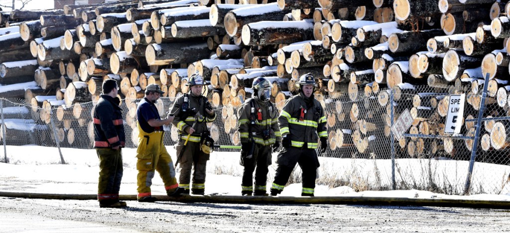 Firefighters from several area departments congregate outside the Hancock Lumber company to assist putting out a fire at the mill in Pittsfield on Sunday.