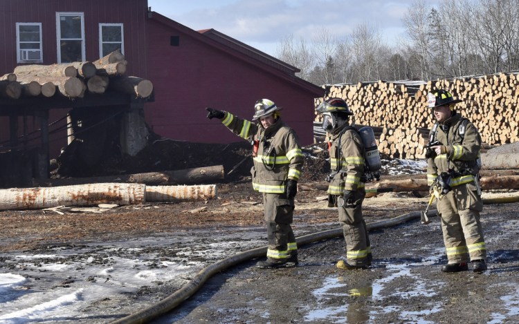Firefighters convene at one end of the Hancock Lumber company sawmill building in Pittsfield where fire was reported on Sunday.
