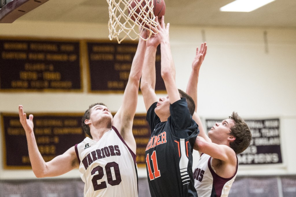 Gardiner's Logan Carlton, center, battles for the rebound with Nokomis' Zach Hartsgrove, left, and Josh Smestad during a Kennebec Valley Athletic Conference Class A game Thursday night in Newport.