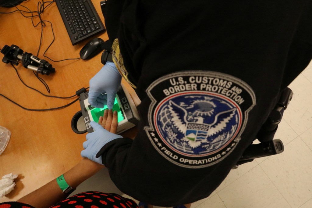 A woman who is seeking asylum has her fingerprints taken by a U.S. Customs and Border Protection officer in McAllen, Texas, last May.