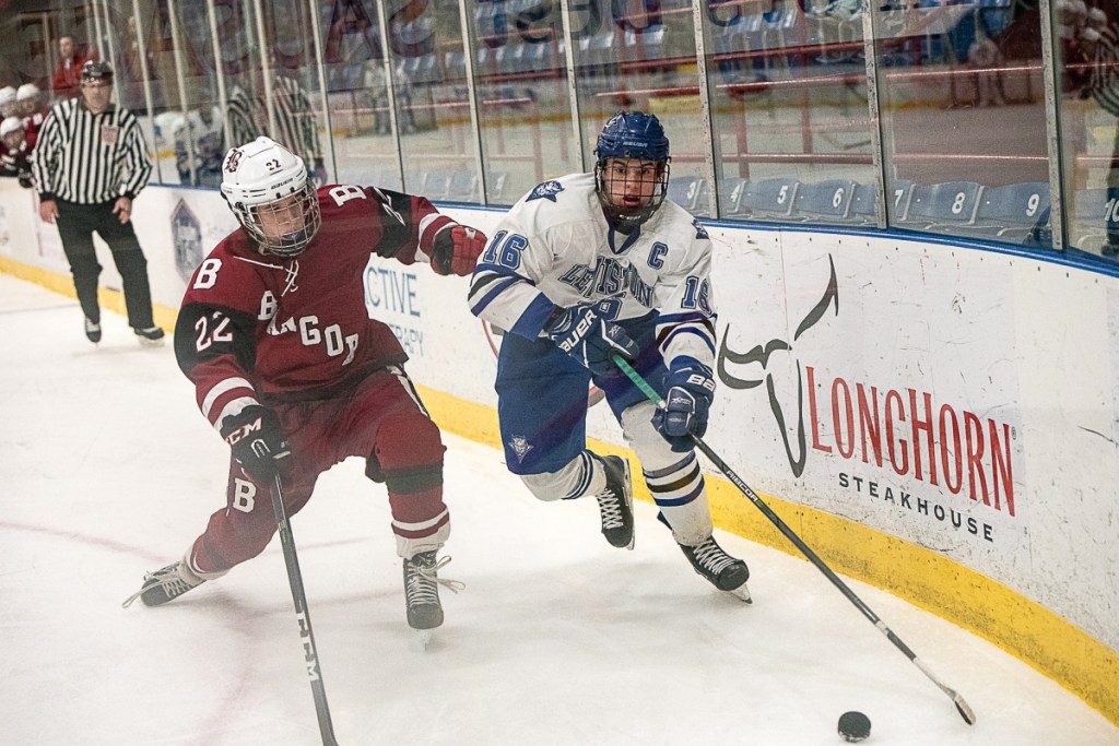 Bangor's Anthony Caccese and Lewiston's Alex Robert struggle for control of the puck during a Class A North game Friday night in Lewiston.