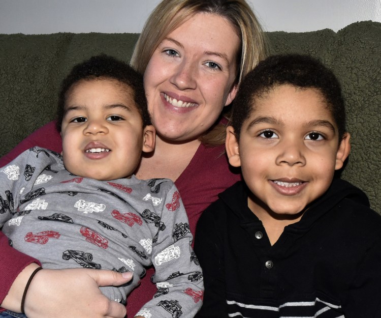 Mindy Saint Martin holds her sons Marcus, left, and Donovan at their home in Waterville on Monday.
