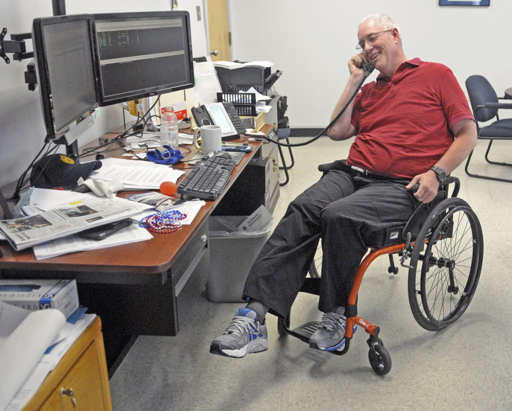Chief Robert Gregoire, of the Augusta Police Department, does leg lift exercises while talking on the phone July 9, 2015, in his manual wheelchair at police headquarters in Augusta. Gregoire plans to retire as police chief in about four months.
