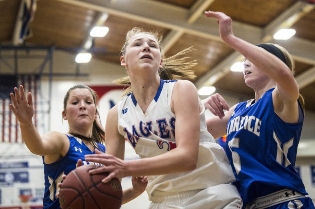 Messalonskee sophomore Gabrielle Werner (3) grabs a rebound as  Lawrence defenders Brooklynn Lambert, right, and Lexi Lewis close in  during a Kennebec Valley Athletic Conference Class A game Wednesday night in Oakland.