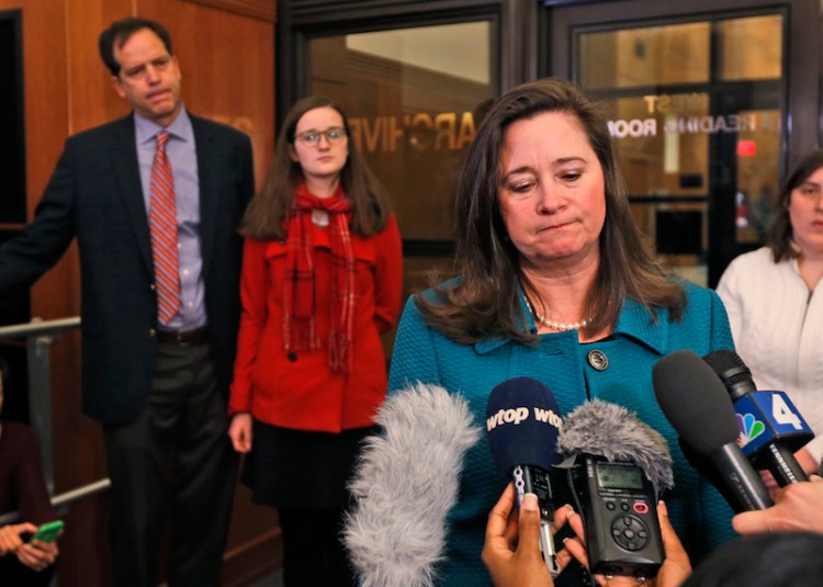 Democratic candidate for the 94th House of Delegates seat, Shelly Simonds, right, speaks to the media as her husband, Paul Danehy, left, and daughter, Georgia Danehy, center, look on after a drawing to determine the winner of a tied election in Richmond, Va.