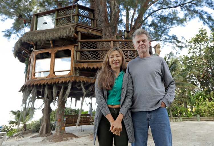 Lynn Tran and her husband Richard Hazen with their Australian pine treehouse in Holmes Beadh, Fla. 