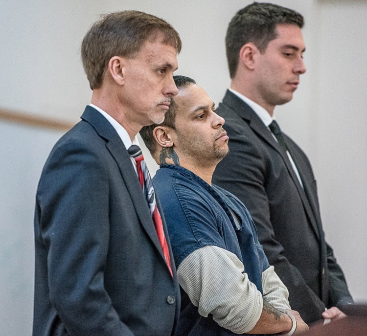 Travis Therrien is flanked by his lawyers in Androscoggin County Superior Court in Auburn for his sentencing Thursday. He was sentenced to 13 years in prison for kidnapping a developmentally delayed 14-year-old girl.