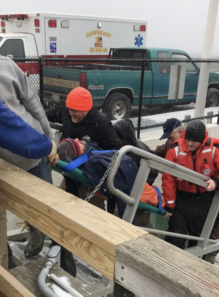 A U.S. Coast Guard crew transfers one of four people rescued after their 14-foot skiff capsized in Deep Cove near Eastport on Tuesday.